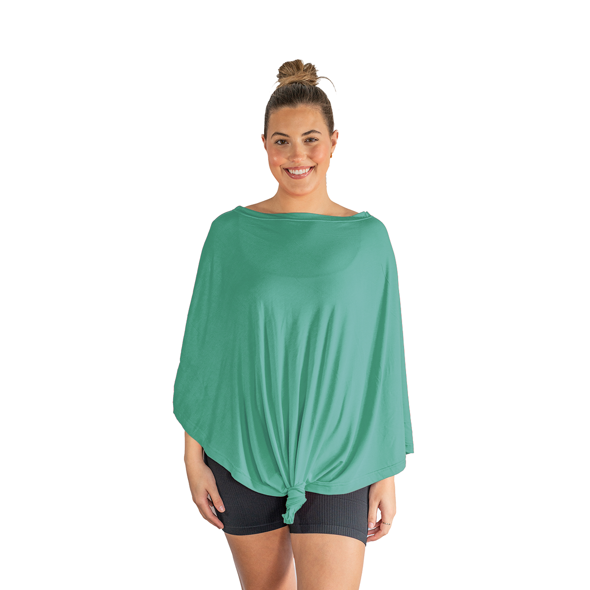 Woman wearing a green poncho over a black top and shorts on a white background