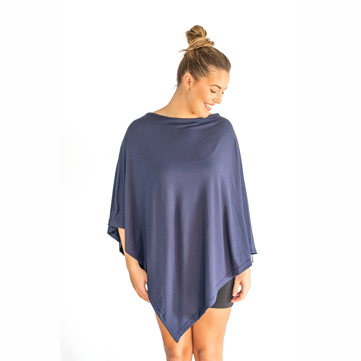 Woman wearing a navy blue poncho on a white background