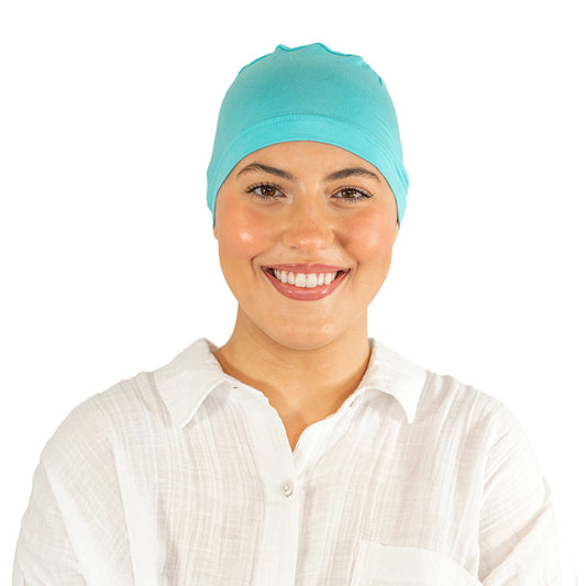 Woman wearing a teal headscarf on a white background
