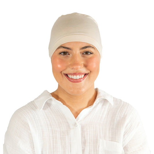 Woman wearing a beige headscarf on a white background