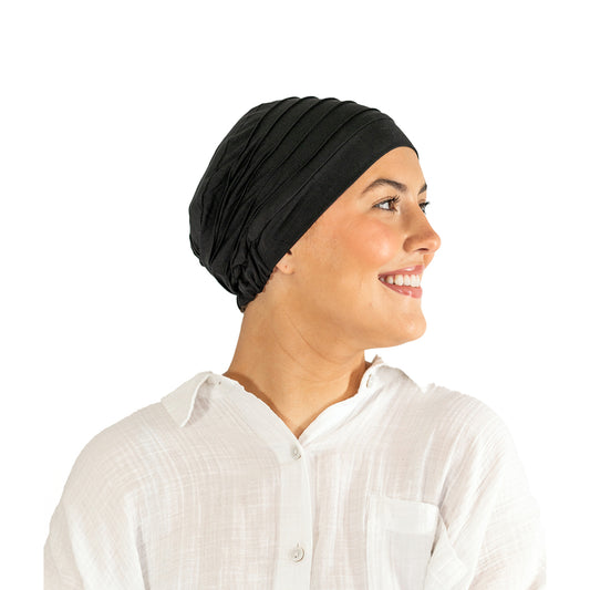 Woman wearing a black headscarf and white shirt on a white background