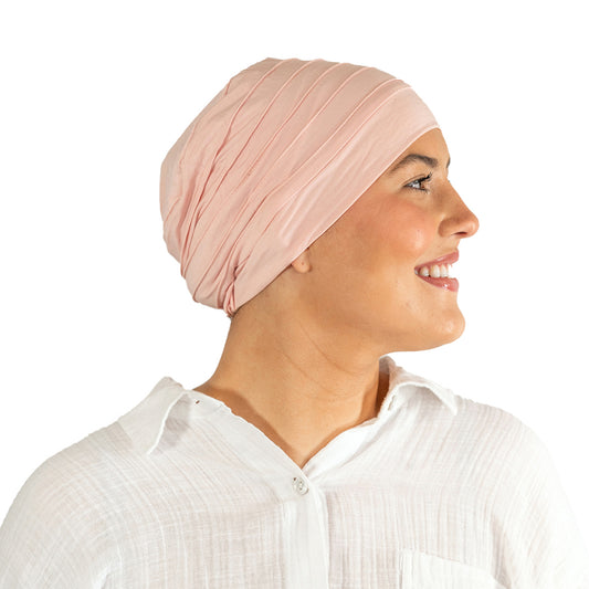 Woman wearing a light pink turban on a white background