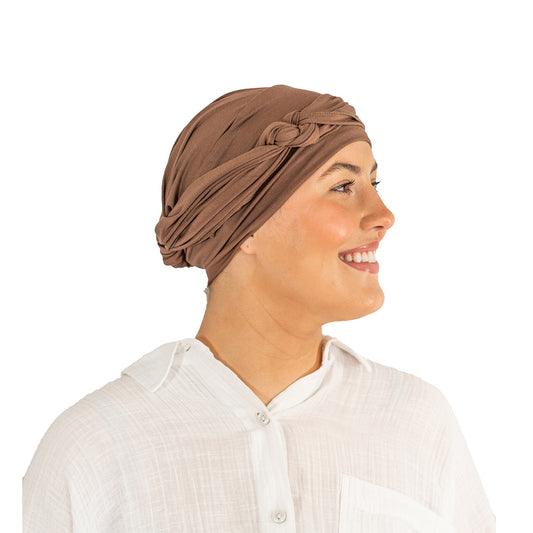 Woman wearing a brown headscarf on a white background