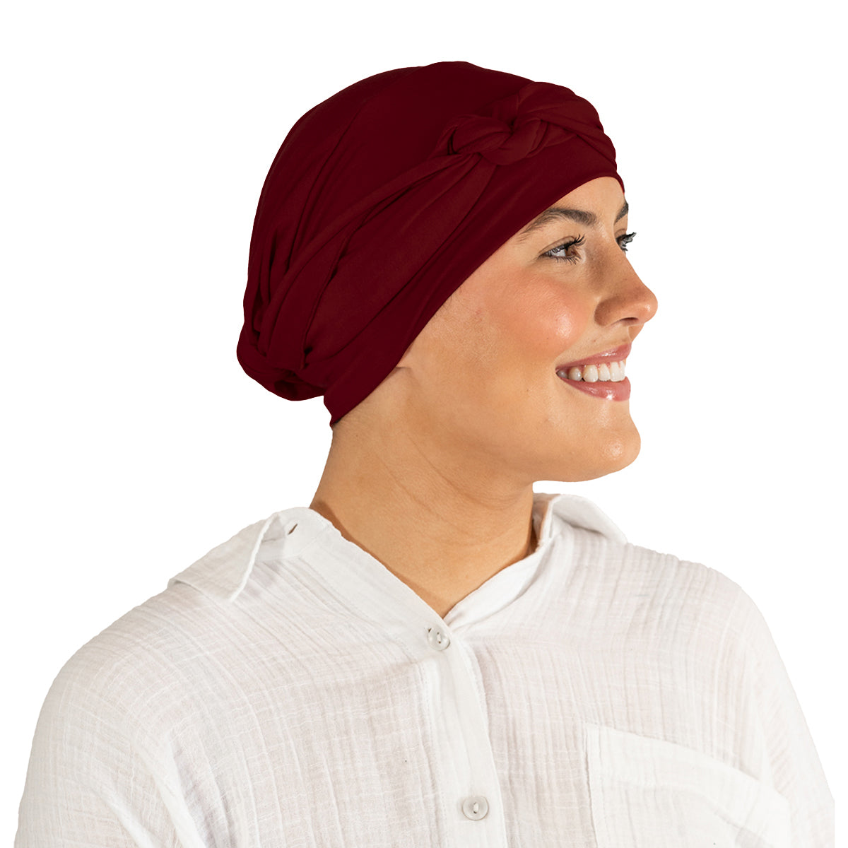 Woman wearing a maroon headscarf and white shirt on a white background
