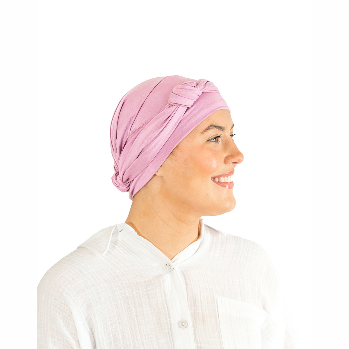 Woman wearing a pink headscarf with a bow on a white background