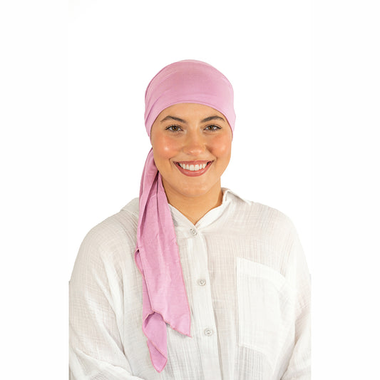 Woman wearing a pink headscarf on a white background