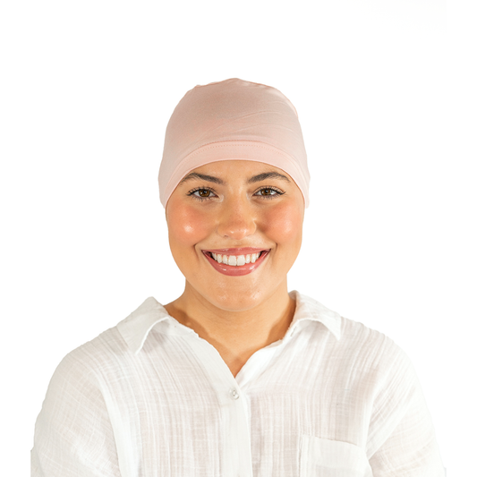 Woman wearing a pink headscarf on a white background