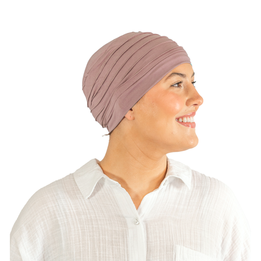 Woman wearing a mauve headscarf on a white background
