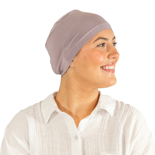 Woman wearing a beige headscarf on a white background