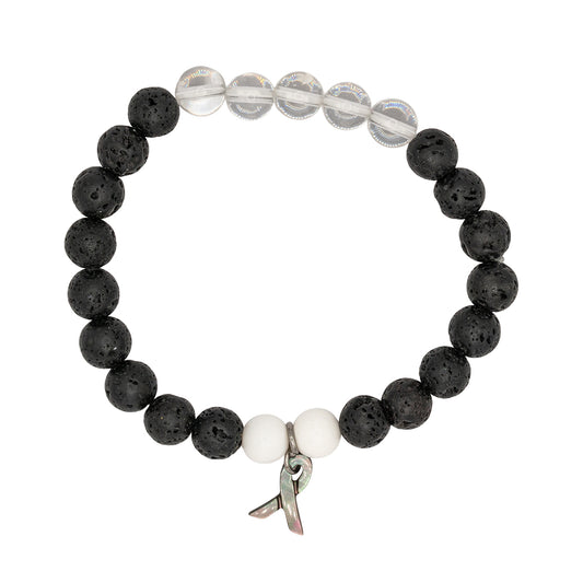 Black and white beaded bracelet with a metal charm on a white background
