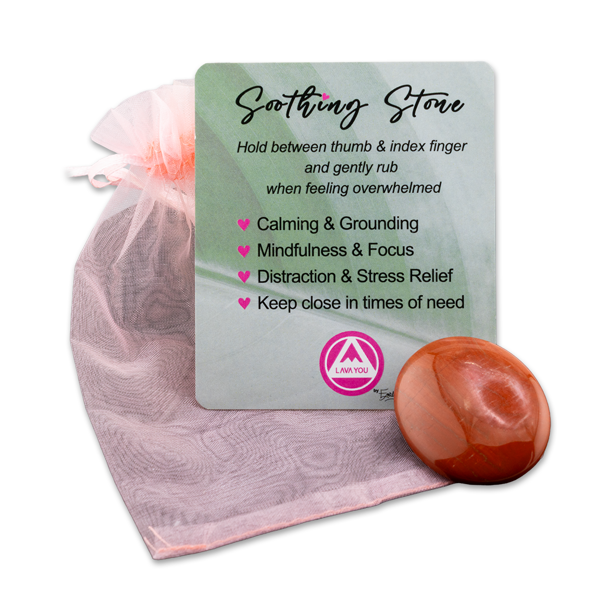 A soothing stone with a card explaining its benefits, placed on a pink drawstring bag.