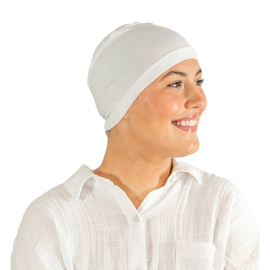 Woman wearing a white headscarf and white shirt on a white background