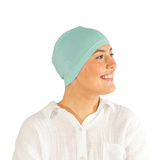 Woman wearing a light blue headscarf on a white background